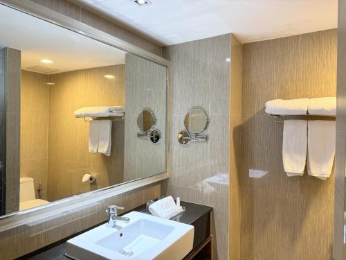 a bathroom with a sink and a mirror at Ramada Sukhumvit Soi Eleven in Bangkok