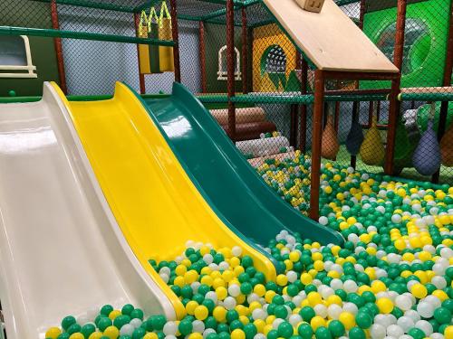 Ein Spielplatz mit einem Rutsch in einem Haufen Bälle in der Unterkunft Aries Hotel & SPA Szczyrk in Szczyrk