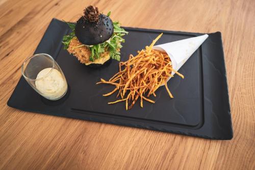 a black plate with food on a table at Résidence Valdys Thalasso & Spa - les Pins in Saint-Jean-de-Monts