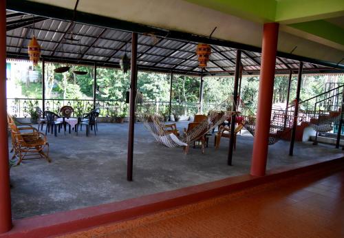 duży pokój z krzesłami, stołami i oknami w obiekcie Green View w mieście Thekkady