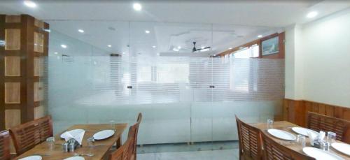 a dining room with tables and chairs and sinks at Hill Pine View in Dharamshala