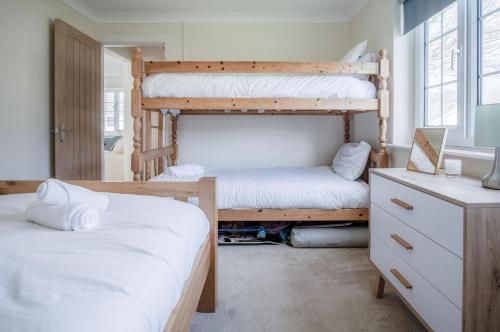 a bedroom with two bunk beds and a dresser at Eddies - 2 Bedroom Chalet – Scurlage in Knelston