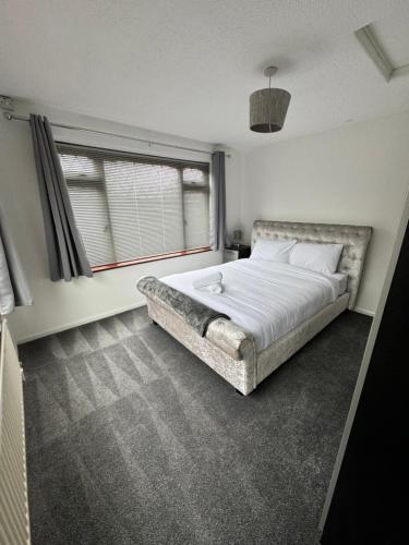 um quarto com uma cama grande e uma janela em Luxary private detached property em Brettell Lane