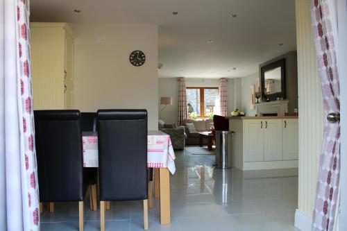 a kitchen and living room with a table and chairs at Cosy Holidayhomes Kerry in Kenmare