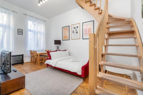 um quarto com uma cama e uma escada em espiral em Park Strzelecki Two-Level Apartment em Cracóvia