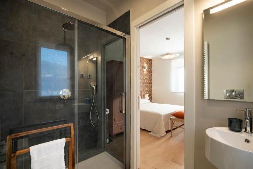 a bathroom with a shower and a sink and a bedroom at Borgo Isasco in Finale Ligure