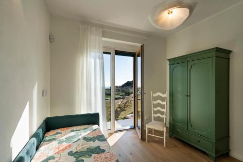 a bedroom with a green cabinet and a bed and a window at Borgo Isasco in Finale Ligure