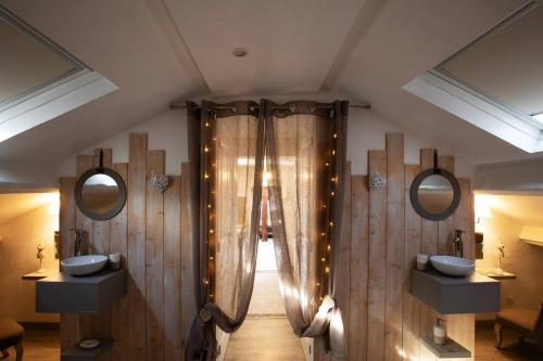 une salle de bain avec deux lavabos et deux miroirs dans l'établissement Appartement cosy à Clermont-Ferrand 35 m² proche commodités, à Clermont-Ferrand