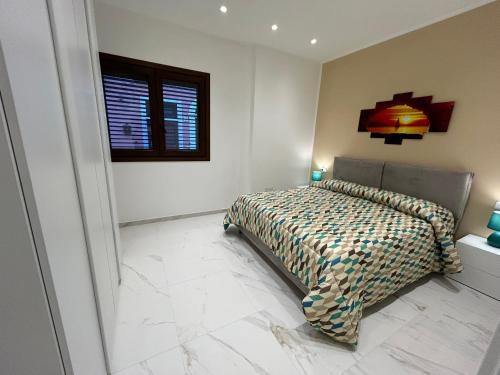 Schlafzimmer mit einem Bett und einem Fenster in der Unterkunft Ficodindia in Pozzallo