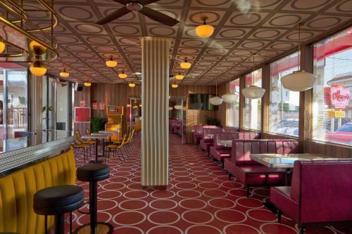 a restaurant with red chairs and tables and a pillar at Romeos Ibiza - Adults Only in San Antonio Bay