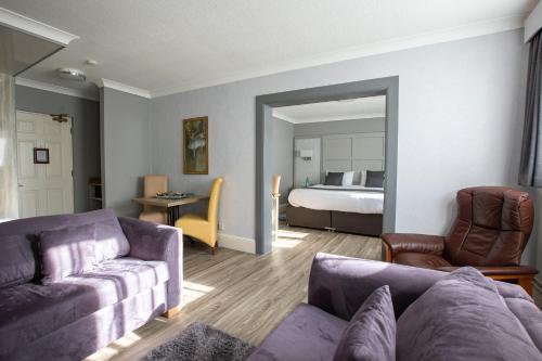 a living room with a couch and a bedroom at Best Western Manor Hotel in Gravesend