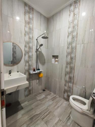 2 bedroom, 1 kitchen في جاكرتا: حمام مع حوض ومرحاض ومرآة