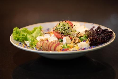 a plate of food with vegetables on a table at Hotel Allegra in Zuoz