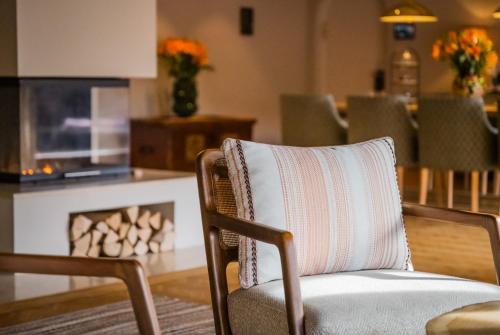 a pillow sitting on a chair in a living room at Spa & Resort Bachmair Weissach, LUXURY FAMILY RESORT in Rottach-Egern