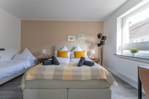 a bedroom with a large bed with yellow pillows at E&K Apartment kleine Bandstraße in Wuppertal