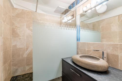 uma casa de banho com um lavatório de pedra sobre um balcão em Les Restanques par Dodo à Cassis em Cassis