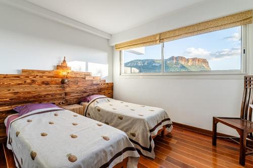 Duas camas num quarto com uma janela em Les Restanques par Dodo à Cassis em Cassis