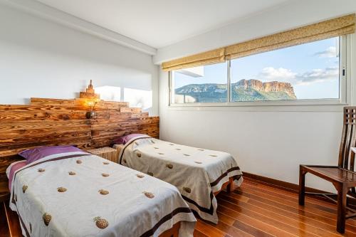 two beds in a room with a window at Les Restanques par Dodo à Cassis in Cassis