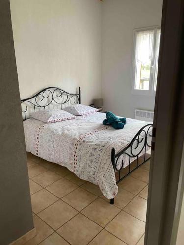 une chambre avec un lit avec un animal en peluche dessus dans l'établissement Appart*Résidence piscine*Parking*3mn Centre Sarlat, à Sarlat-la-Canéda