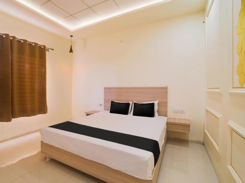 a bedroom with a large bed in a room at OYO Saubhagya Shri Resort in Hoshangābād