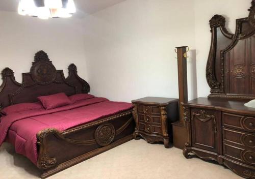 1 dormitorio con cama grande de madera y mesita de noche en شقة مفروشة 4غرف نوم شارع الجامعة, en Amán