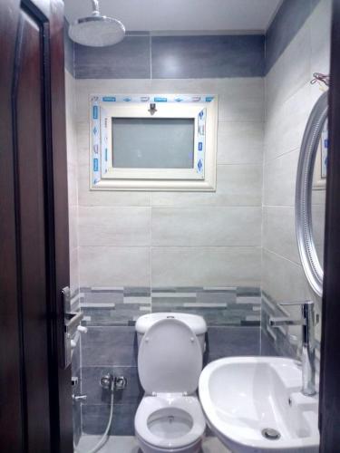 ein Bad mit einem WC und einem Waschbecken in der Unterkunft مساكن شيراتون المطار in Kairo