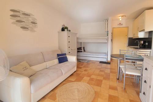 un salon avec un canapé blanc et une cuisine dans l'établissement Cosy family cocoon with beautiful loggia, à Fréjus