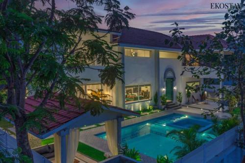 an exterior view of a house with a swimming pool at EKOSTAY Luxe - CASABLANCA VILLA in Igatpuri