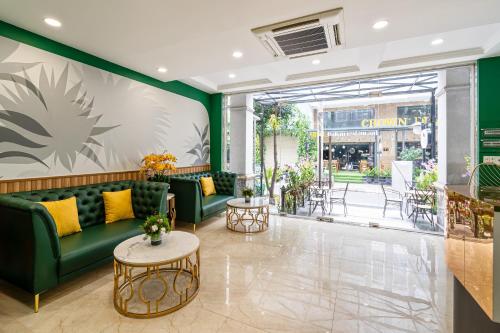 a lobby with green couches and a table at El Ocaso Boutique Hotel in Ho Chi Minh City