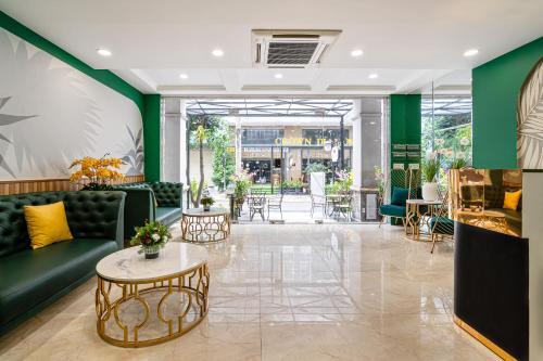 een lobby met een groene bank en een tafel bij El Ocaso Boutique Hotel in Ho Chi Minh-stad