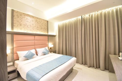 een slaapkamer met een bed in een kamer bij La Dhalia By Glitz Hotels in Thane