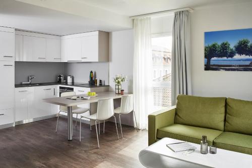 a kitchen and living room with a table and a couch at Base Nyon in Nyon
