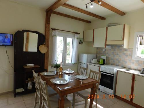 een keuken met een houten tafel met stoelen en een tafel en een tafel bij Adonino Residence-The House of Pomegranates in Lakíthra