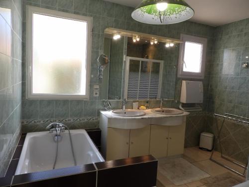 La salle de bains est pourvue de 2 lavabos, d'une baignoire et d'une fenêtre. dans l'établissement St Cyprien Magnifique villa avec piscine, à Saint-Cyprien