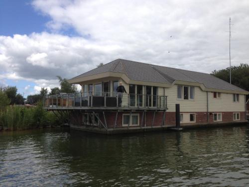 a house on the side of a boat on the water at Water Villa, Houseboot at the Lake, Great Views, 70 km to Amsterdam in Biddinghuizen