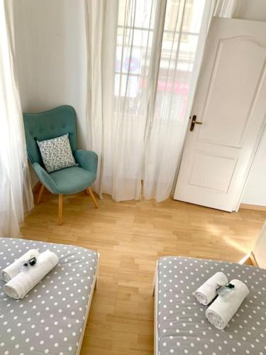 - une chambre avec deux lits, une chaise et une porte dans l'établissement Saint Philippe - T3 près de la plage, à Nice