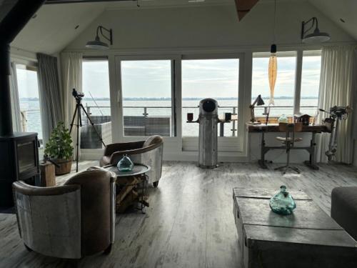 a living room with a couch and a table at Water Villa, Houseboot at the Lake, Great Views, 70 km to Amsterdam in Biddinghuizen