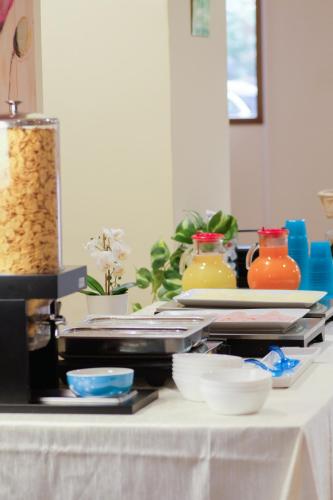 a table with plates of food and bowls on it at Hp Fly Hotel Bologna in Calderara di Reno