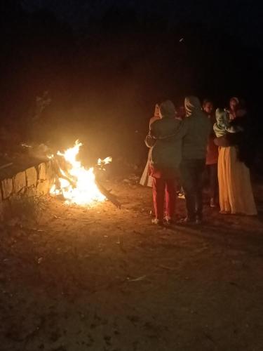 a group of people standing around a fire at night at SD Residency - Yercaud in Yercaud