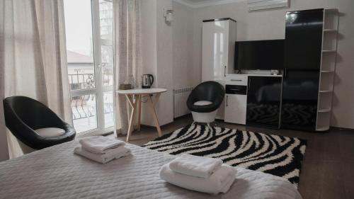 - une chambre avec un lit, 2 chaises et une télévision dans l'établissement Hotel Kalyan, à Chişinău