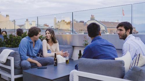a group of people sitting around a table on a rooftop at Base Nyon in Nyon