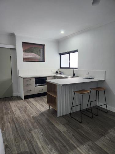 eine Küche mit einem Waschbecken und 2 Hockern in einem Zimmer in der Unterkunft Wambenger Lodge in Collie