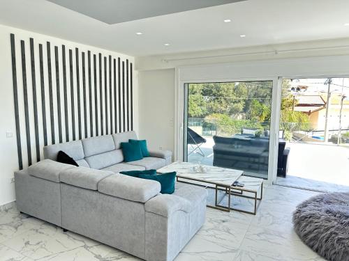 ein Wohnzimmer mit einem Sofa und einem Tisch in der Unterkunft Kasaj Luxury Apartments in Porto Rafti