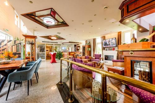 a restaurant with purple chairs and a fireplace at Residenz Hotel Leipzig in Leipzig