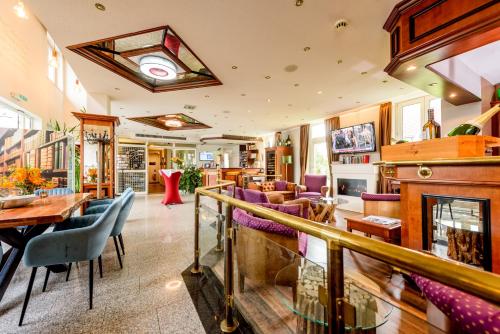 ライプツィヒにあるレジデンツ ホテル ライプチヒの紫色の椅子と暖炉のあるレストラン