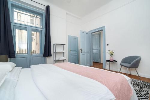 a bedroom with a large white bed and a chair at Designed Spacious Flat with 2 Bedroms and Balcony in Prague