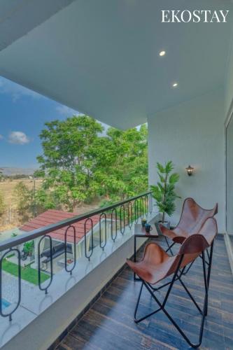 two chairs sitting on a balcony with a view at EKOSTAY Luxe - CASABLANCA VILLA in Igatpuri