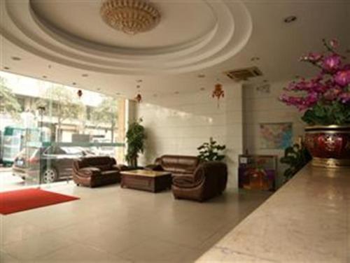 una sala de estar con sofás y sillas y un techo en Yidun Hotel Foshan Luocun en Huanshi