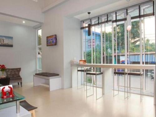 - un salon avec un bar, des chaises et des fenêtres dans l'établissement Soontree House Hotel, à Udon Thani