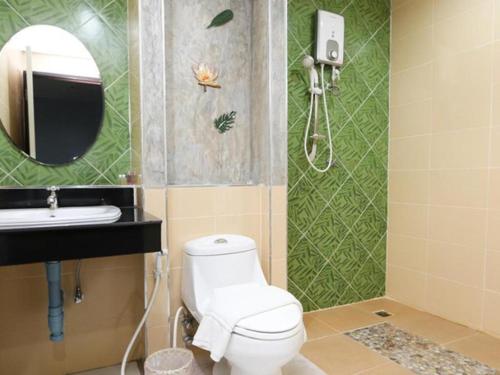 La salle de bains est pourvue de toilettes, d'un lavabo et d'un miroir. dans l'établissement Soontree House Hotel, à Udon Thani